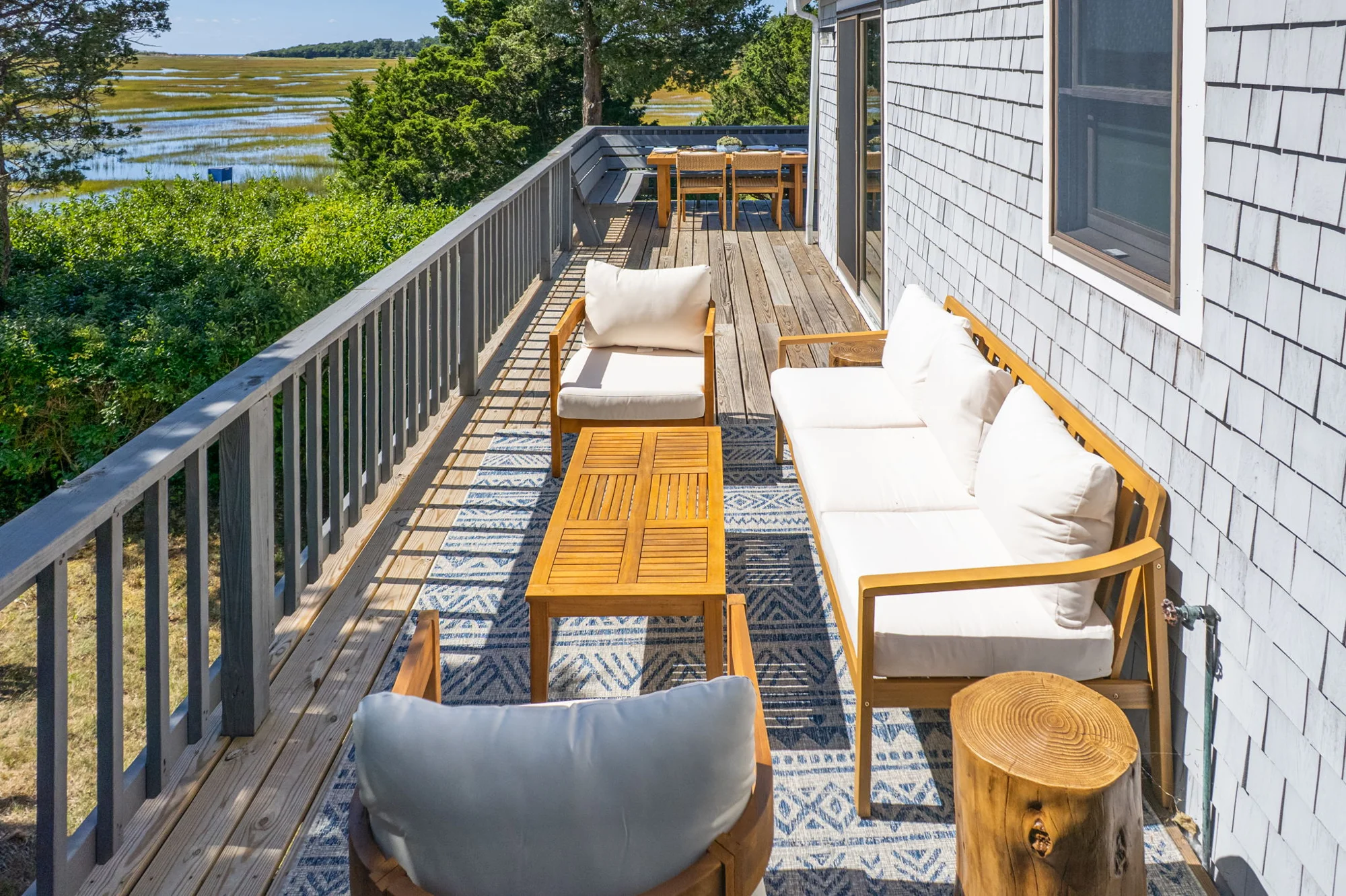 Cushioned lounge seating on the deck overlooking the marsh